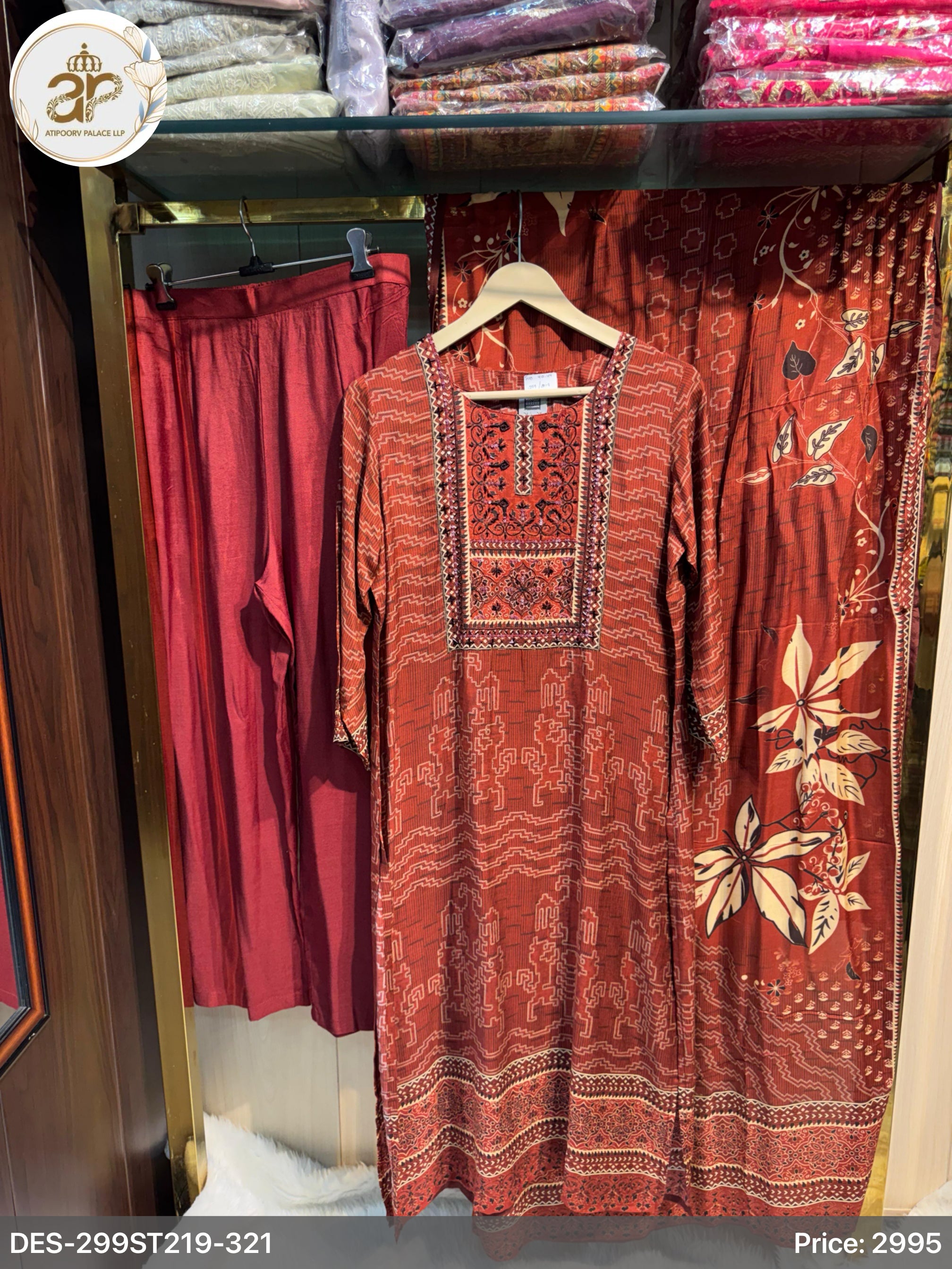 Red embroidered dress on a hanger with red pants in the background