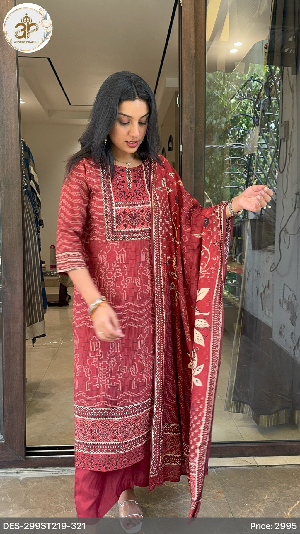 Woman wearing a red embroidered traditional outfit in a store setting