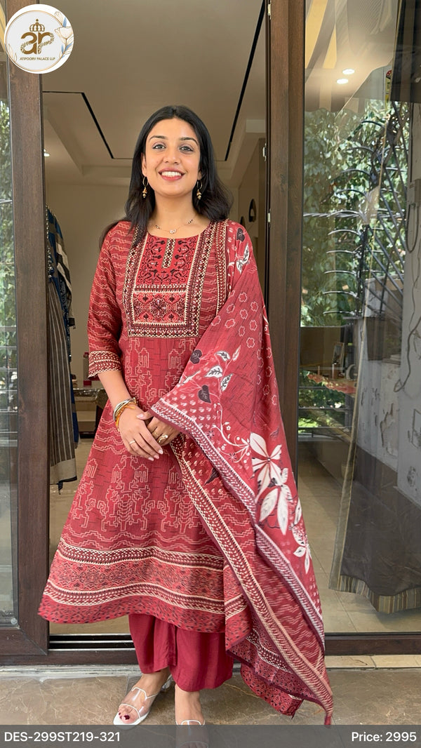 Woman wearing a red traditional outfit with floral patterns in an indoor setting.